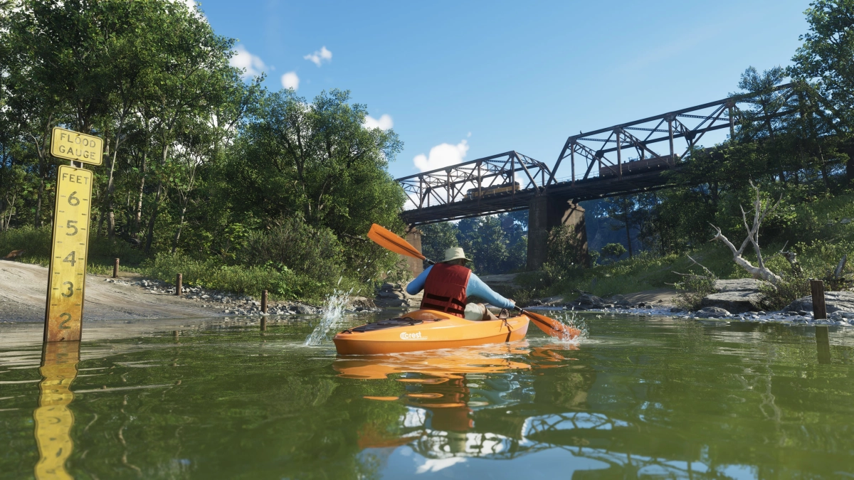 A person wearing a life vest kayaks toward a bridge in Mount Kalaga National Park. A person wearing a life vest kayaks toward a bridge in Mount Kalaga National Park.